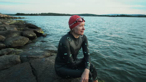 Sportswoman-in-Swimsuit-Sitting-on-Lakeshore-after-Training